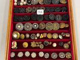 une vitrine remplie d'une multitude de boutons et de broches
