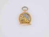 a close up of a gold pocket watch on a white surface