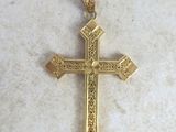 un gros plan d'une croix en or posée sur une surface en marbre