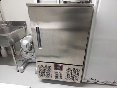 un réfrigérateur en acier inoxydable situé à côté d'un évier dans une cuisine