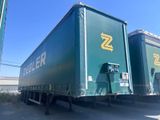 une semi-remorque verte arborant un logo « z » jaune sur le côté