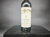 une vieille bouteille de vin posée sur une boîte noire