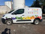 a van that is parked in a lot with a lot of fruit on it