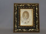 an old picture of a man in a black and gold frame