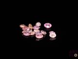 some pink and white diamonds on a black surface