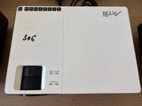 a white projector with a remote on top of it