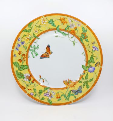 yellow and orange plate with a butterfly and flowers on it