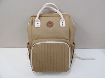 un sac à dos beige posé sur une table blanche