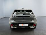 the rear end of a grey car in a white room