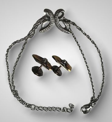 une photo représentant un collier et deux paires de boucles d'oreilles suspendues à une chaîne
