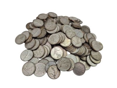 une pile de vieilles pièces d'argent sur une surface blanche