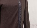 the mannequin is wearing a brown sweater and black pants