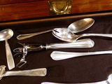 beaucoup de cuillères en argent et de cuillères à soupe sur une table
