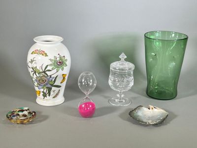 a green glass vase sitting next to a green vase and other items