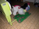 a toy horse that is laying on the floor next to a phone