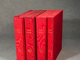 trois livres rouges superposés sur une table
