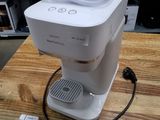 une cafetière blanche posée sur une table en bois dans un magasin