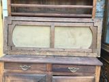 an old wooden cabinet with a glass door on top