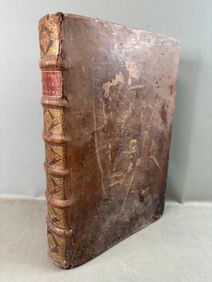 an old book sitting on top of a table next to a wall