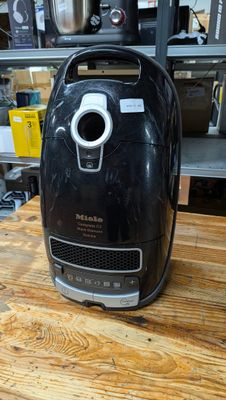 une friteuse à air chaud noire posée sur une table en bois