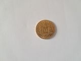 a gold coin on a white surface with a white background