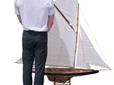 a man standing next to a model of a sailboat
