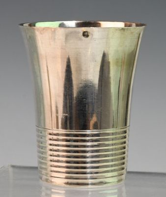 une coupe en argent posée sur une table en verre