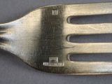 a metal fork with a metal handle on a table