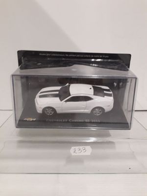 a white toy car in a clear box on a table