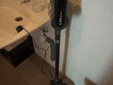 a vacuum that is sitting next to a sink in a bathroom