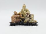 an image of a figurine of three people sitting on a bed