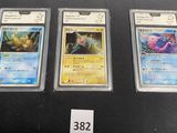 three pokemon cards are sitting on a table with a price tag