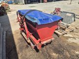 un tracteur rouge et bleu recouvert d'une bâche bleue