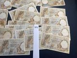 a lot of french bank notes sitting on a table