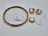 un ensemble de bagues et de boucles d'oreilles en or sur un fond blanc