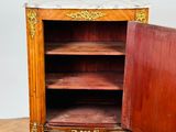 a wooden cabinet with a marble top on a wooden floor