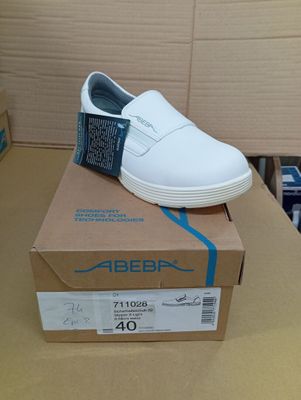 une boîte sur laquelle est posée une paire de chaussures blanches