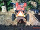 un tracteur rouge garé dans l'herbe