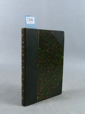 un vieux livre posé sur une table blanche, à côté d'une étiquette bleue