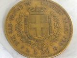 a close up of a gold coin with a coat of arms on it