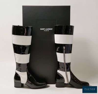 La paire de bottes noires et blanches se trouve à côté d'une boîte noire