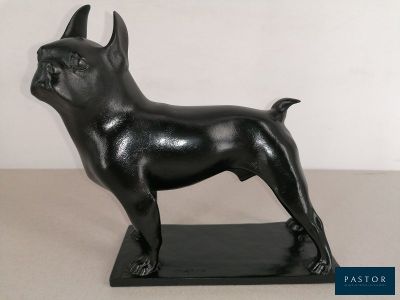 statue d'un chien noir sur un socle noir, avec un fond blanc