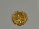 a close up of a gold coin on a white surface