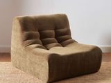 the brown chair is sitting on the carpet in the room