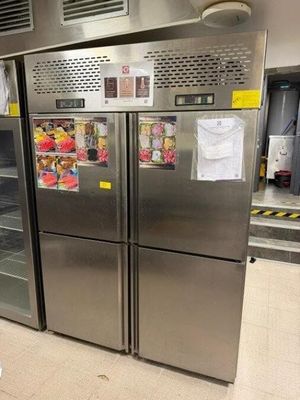 Des réfrigérateurs en acier inoxydable sont alignés dans un magasin, leurs portes ouvertes.