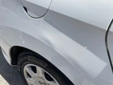 a white car with a black rim parked on the side of the road