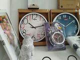 a desk with a clock, a picture frame, a picture, and other items on it