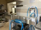 a machine that is sitting in a kitchen with a blue hose