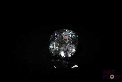 gros plan d'un diamant bleu sur une surface noire