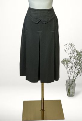 a dress on a mannequin stand next to a vase of flowers